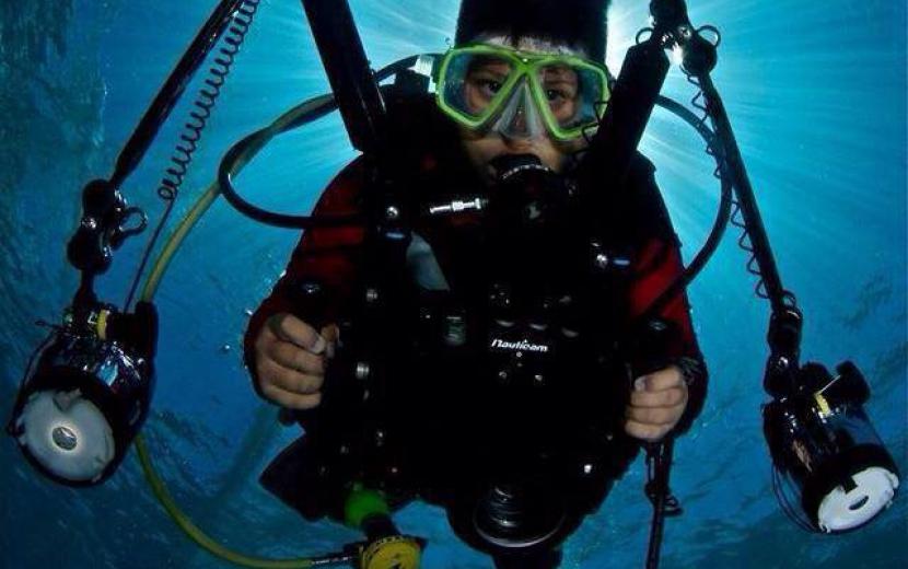 diver holding his camera underwater on the PADI course