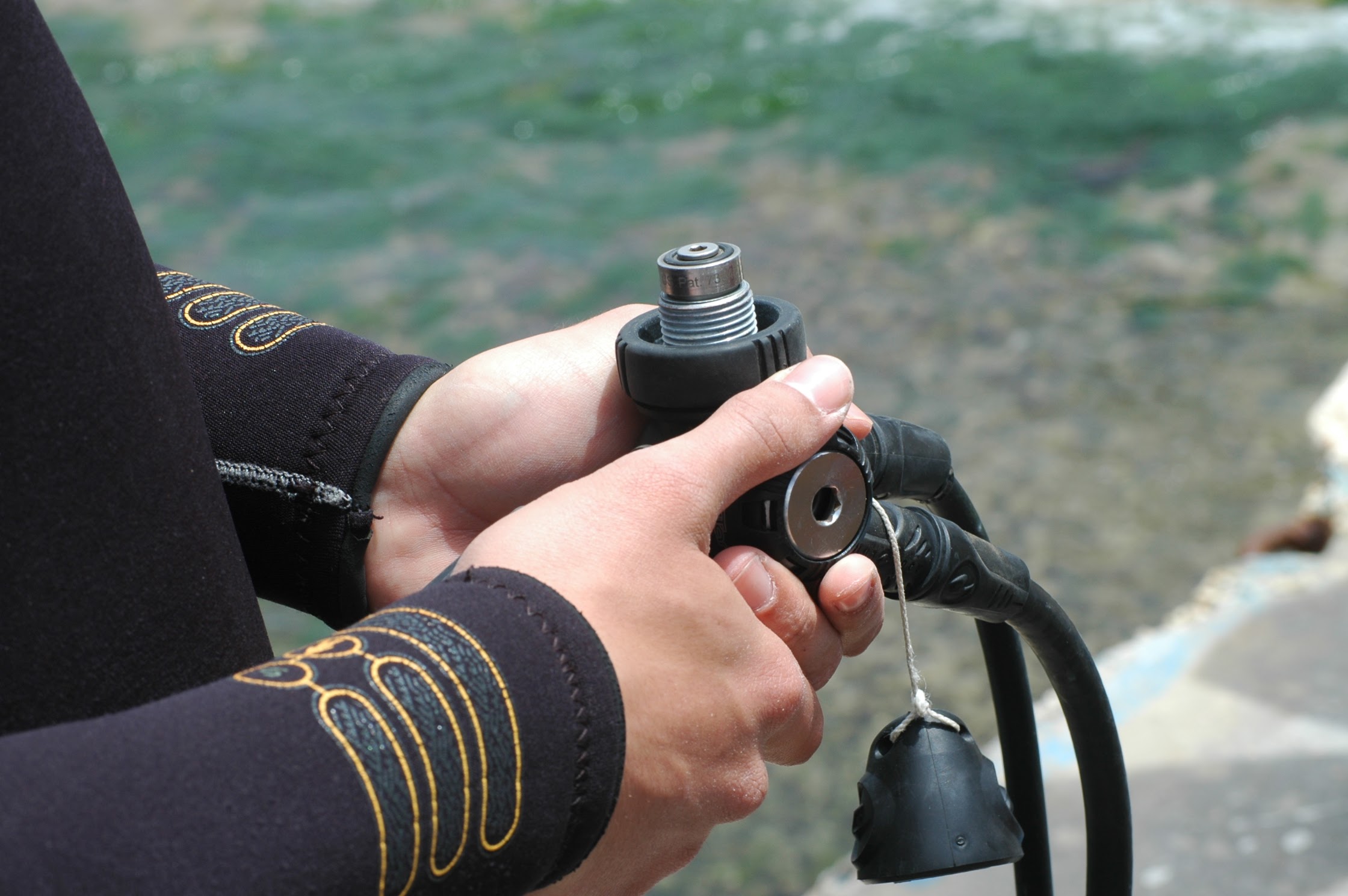 the diver is holding the regulator in his hands